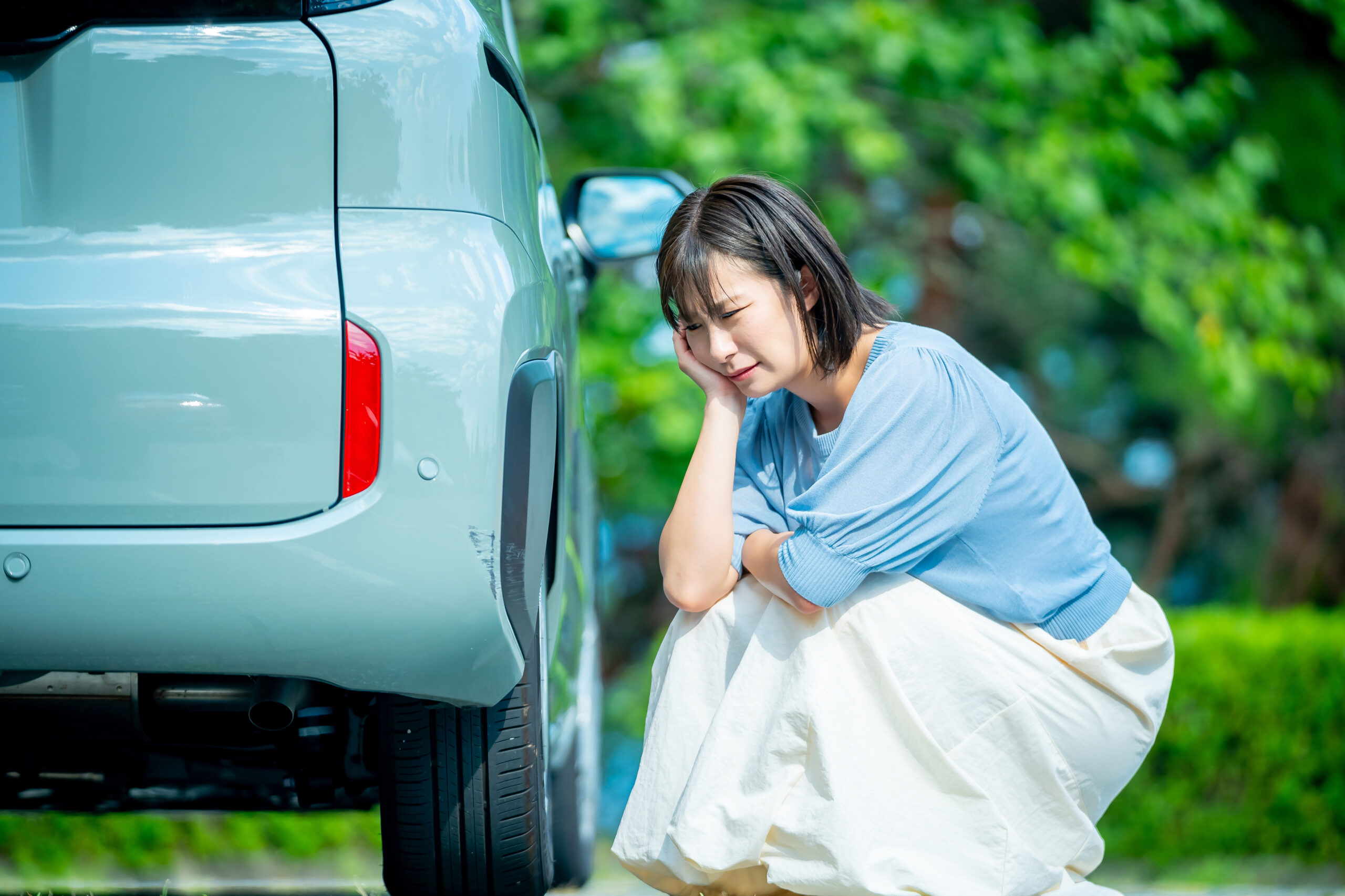 車を傷つけて悩んでいる女性